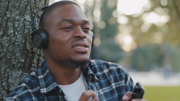 Male Portrait African American Young Guy Funny Man in Headphones Listening to Music Using Phone