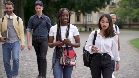 Positive Multiracial Students Chatting During Walk