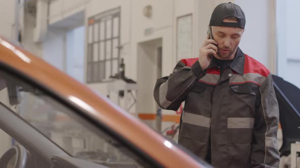 Mechanic Talking on Phone in Auto Repair Shop