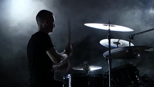 Drummer Plays Energetic Music on the Drum, Black Background, Side View, Slow Motion