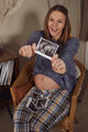 Smiling pregnant woman holding out ultrasound scan photo of baby - PhotoDune Item for Sale