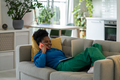 Cheerful smiling African American woman relaxing lying on sofa and talking with boyfriend on phone - PhotoDune Item for Sale
