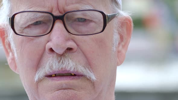 Grandpa's Face is Wrinkled He is Sitting Pensively on a Bench in the Park