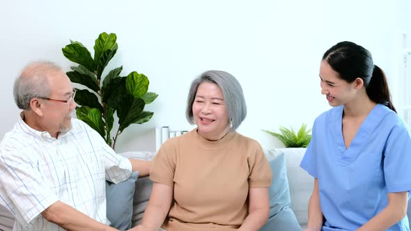 A young Asian nurse take care a disability senior while she sitting on a wheel chair.