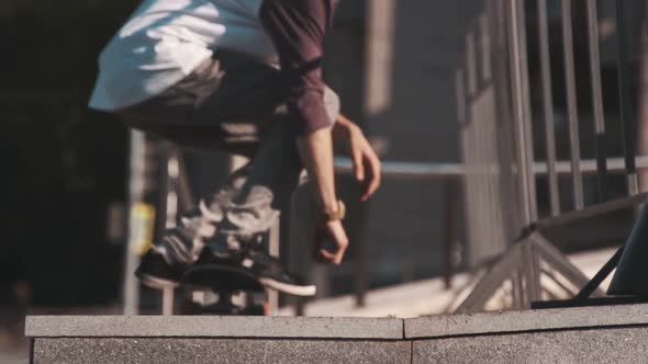 Young Man Spending His Leisure Time in the City. The Guy Tricking on Skateboard. Skateboarder in