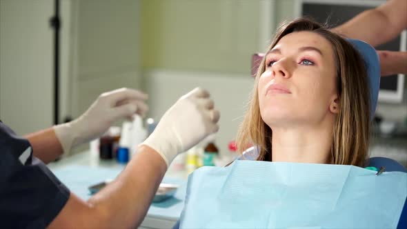 Dentist Giving Female Patient Protective Orange Goggles