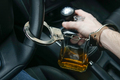 Man in handcuffs holds bottle of alcohol in car. Drunk driving concept. Don't drink and drive. - PhotoDune Item for Sale
