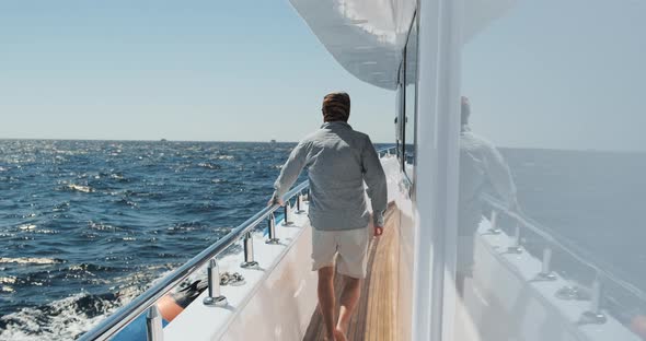 Man Walks on Moving Yacht Deck on Sunny Summer Day