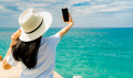 Young Asian woman wear straw hat in casual style use smartphone taking selfie at wooden pier. Summer - PhotoDune Item for Sale