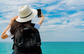 Young Asian backpacker woman wear hat use smartphone taking selfie at pier. Summer vacation  - PhotoDune Item for Sale