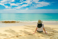 Happy young woman in white shirts and shorts sitting at sand beach. Relaxing and enjoying holiday - PhotoDune Item for Sale