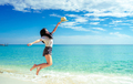 Happy young woman in casual style fashion and straw hat jumping at sand beach. Relaxing and enjoy - PhotoDune Item for Sale