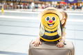Girl with big funny suitcase, bag in airport terminal. Waiting for boarding to flight. Happy  - PhotoDune Item for Sale