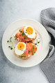 Sandwich with delicious toppings on top: smoked salmon, eggs, herbs and microgreens radish, black se - PhotoDune Item for Sale