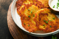 Potato pancakes. Fried homemade potato pancakes or latkes with cream and green onions in rustic plat - PhotoDune Item for Sale