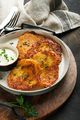 Potato pancakes. Fried homemade potato pancakes or latkes with cream and green onions in rustic plat - PhotoDune Item for Sale
