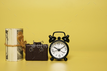 and alarm clock on copyspace yellow background. Rising living cost concept.