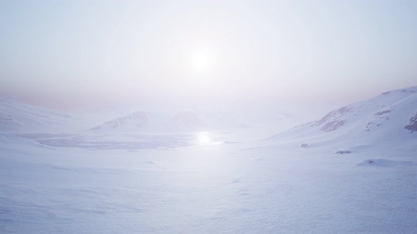 Aerial Landscape of Snowy Mountains and Icy Shores in Antarctica alt