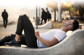 Man lying near the sea on a bench - PhotoDune Item for Sale
