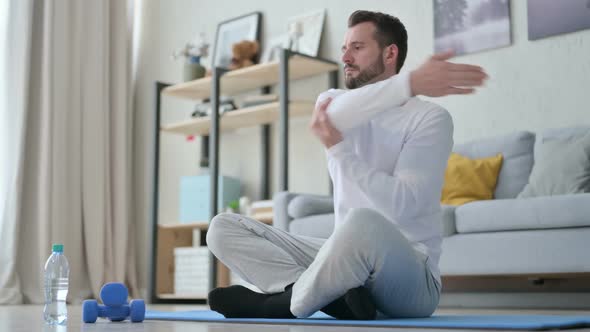 Man Doing Stretches on Yoga Mat at Home