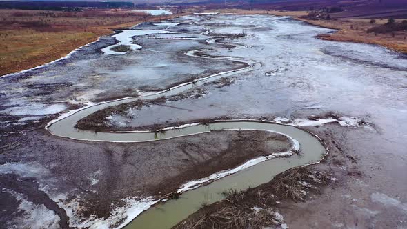 Tortuous river in muddy place. Ecological problems with water. Global warming. 