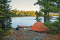 Campsite with orange tent and canoe on northern Minnesota lake at sunrise during autumn - PhotoDune Item for Sale
