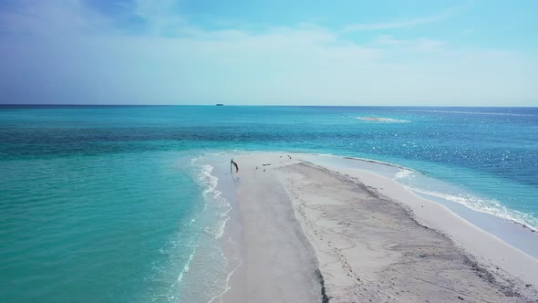 Wide angle above island view of a sandy white paradise beach and blue sea background in hi res 4K