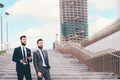 Two young businessmen outdoors walking downstairs talking and chatting - PhotoDune Item for Sale