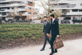 Two young elegant businessmen walking outdoors together in the streets - PhotoDune Item for Sale