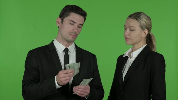 Young Male Professional Giving Dollar To Female Professional, Chroma Key