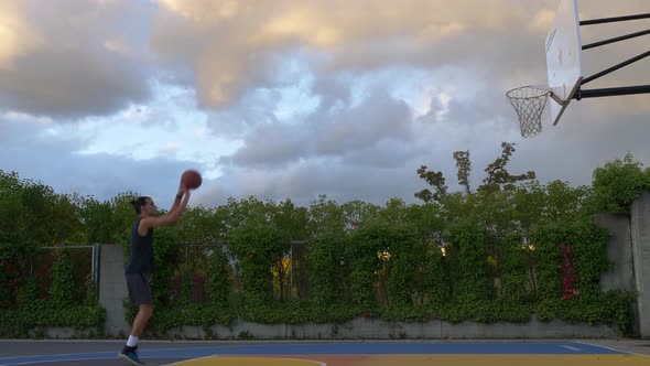 Youngman with sportswear with a basketball practicing shooting and repeating.