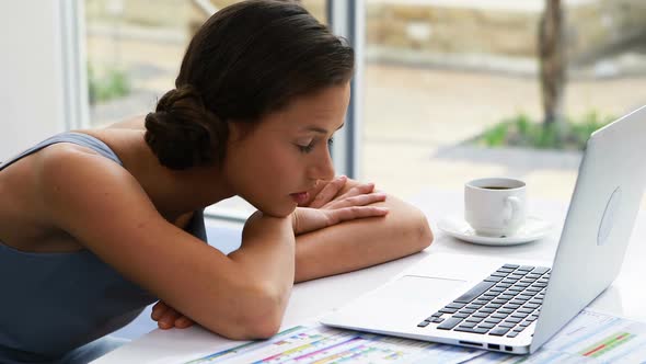 Thoughtful female business executive sitting at desk 4k