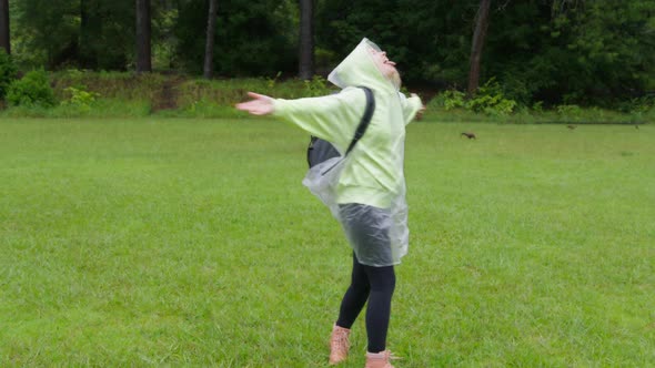 Woman in Rainforest Looking Up Spinning Around on Forest Lawn Under Rain Drops