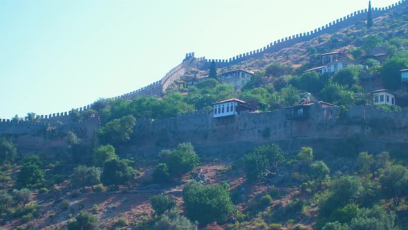 Sea view of ruins of old fortress wall Alanya (Turkey) in sunny summer day, distant medium handheld