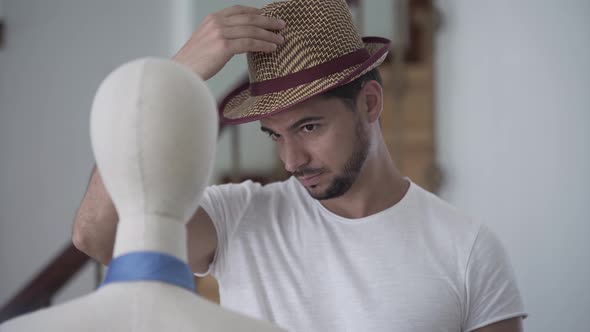 Portrait of a Bearded Man Putting His Hat on the Head of the Mannequin
