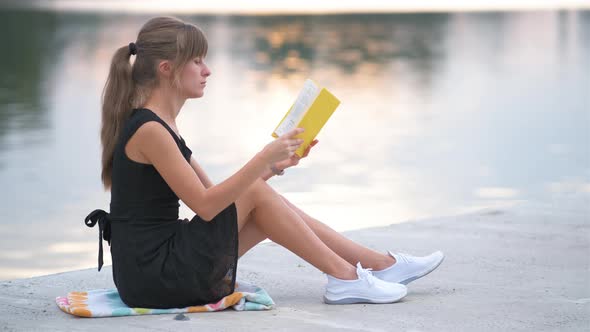 Young Woman Resting in Summer Park Reading a Book
