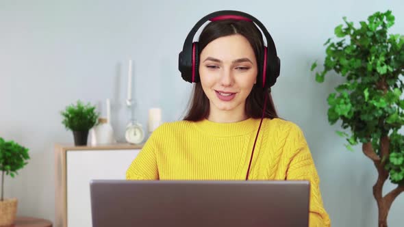 Attractive Woman in Headphones Communicates By Video Communication Using Laptop