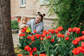 Spring Gardening. Senior woman grandmother and little toddler girl granddaughter Watering tulips - PhotoDune Item for Sale