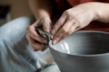Hands female ceramist working with spinning potter wheel to level walls of clay vessel close-up - PhotoDune Item for Sale