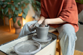Closeup of hands of casual woman ceramist working sits in cozy workshop using potter wheel - PhotoDune Item for Sale