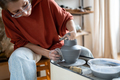 Craftswoman enjoying meditative process of making ceramics, shaping clay on pottery wheel - PhotoDune Item for Sale