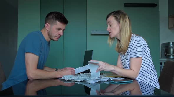 Man and Woman Looking at Payment Bills in the Kitchen