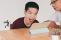 Homeschooling concept by parents of Happy and confidence teenage boy with disability on wheelchair. - PhotoDune Item for Sale