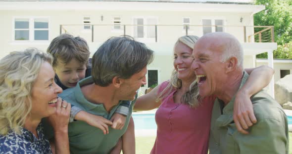 Portrait of happy caucasian family looking at camera in garden