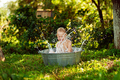 boy having fun, bathing and splashing in old iron bowl on the backyard , happy summertime - PhotoDune Item for Sale