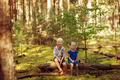 happy cute kids sitting together in forest and looking at camera. - PhotoDune Item for Sale