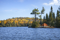 Orange tent on rocky shore of an island on a northern Minnesota trout lake during autumn - PhotoDune Item for Sale