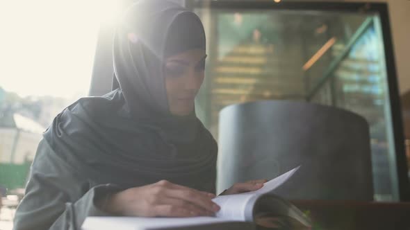 Self-Confident Arabic Lady Reading Book in Cafe, Education and Self-Development