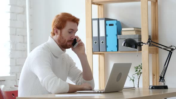 Man with Red Hairs Talking on Phone, Discussing on Smartphone