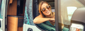 Young woman in sunglasses sitting in camper van leaning on the door - PhotoDune Item for Sale